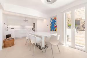 una cucina bianca con tavolo e sedie bianchi di Eternity Blue Villa a Mykonos Città