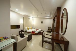 ein Hotelzimmer mit einem Bett und einem Wohnzimmer in der Unterkunft Hotel Amit International in Bhilai