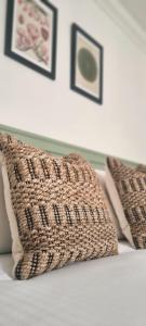 two pillows on a bed with pictures on the wall at Saint Margaret's Guest House in Poole