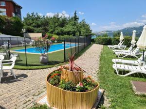 a patio with chairs and a potted plant next to a pool at Logis Hotel Eden Lac in Savines
