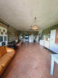 San Lorenzo NuovoにあるCasale Margiulusaの広いリビングルーム(ソファ付)、キッチンが備わります。