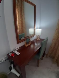 escritorio con espejo, lámpara y silla en Green Living, en Mytilini