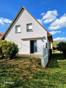 ein weißes Haus mit einer offenen Tür auf einem Hof in der Unterkunft Chez Tony in Wintzenheim