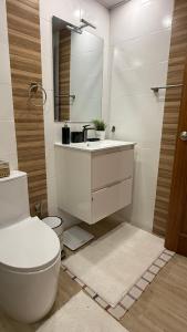 a bathroom with a toilet and a sink and a mirror at Cozy and Beautiful, 3 Bedroom Apartment Home in Santo Domingo +52 photos