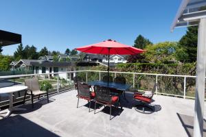 a patio with a table and chairs and an umbrella at Bright & Spacious House Near UBC in Vancouver
