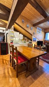 a large wooden table in a kitchen with chairs at Mansarda Chiara - locazione turistica in Gosaldo