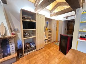 a kitchen with wooden cabinets with a dog sleeping in them at Mansarda Chiara - locazione turistica in Gosaldo +6 photos