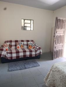 a living room with a couch and a window at Morada das mangueiras em Soure in Soure