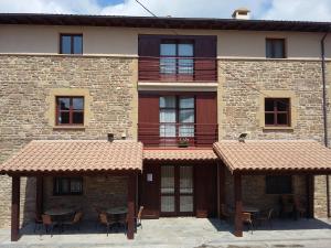 a building with tables and chairs in front of it at Hospedería Prepirineo in Undués-Pintano