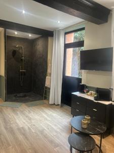 a large bathroom with a shower with a table and a table at La Suite Fernand Bar in Béthune