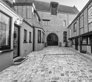 a stone courtyard with a large brick building at La Suite Fernand Bar in Béthune