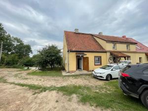 a house with two cars parked in front of it at Mieszkanie niedoskonałe in Pniewo