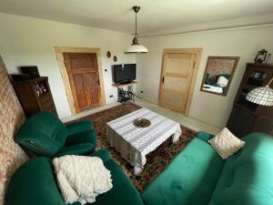 a living room with a green couch and a table at Mieszkanie niedoskonałe in Pniewo