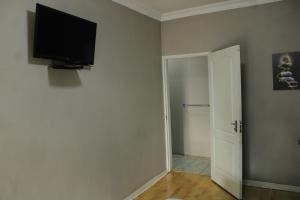 a room with a flat screen tv on the wall at Cockpit Guest House Kempton Park Airport Getaway in Kempton Park