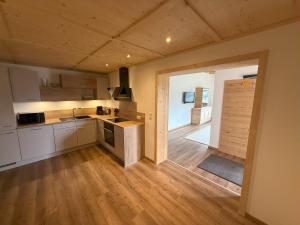 a kitchen with white cabinets and a wooden floor at Ferienhaus Innergruben in Hippach