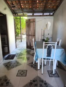 a dining room with a table and chairs on a tiled floor at Morada das mangueiras em Soure in Soure