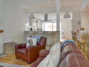 a living room with a leather couch and a kitchen at The Parade - Uk48433 in Bridlington