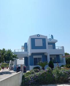 a blue house with a lot of flowers at LiRa in Kremasti