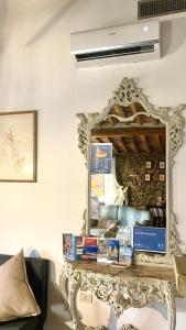 a mirror sitting on top of a table with books at Casa Malù - Dimora Storica in Centro in Suvereto