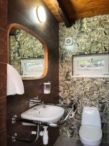 Un baño con lavabo, inodoro y espejo. en Кемпінг, намети, en Surskoye