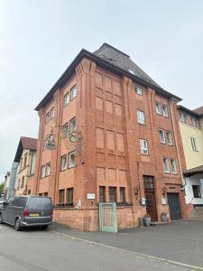 a brick building with a van parked in front of it at Altes Sudhaus in Aschaffenburg