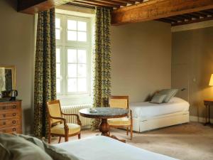 a bedroom with a bed and a table and a window at Gîtes La Grande Ferme Crépon - à la campagne 5mn d'Arromanches et 10mn de Bayeux in Crépon