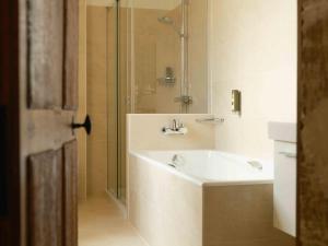 a bathroom with a tub and a sink and a shower at Gîtes La Grande Ferme Crépon - à la campagne 5mn d'Arromanches et 10mn de Bayeux in Crépon +29 photos
