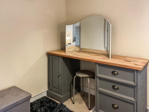 einen Schminktisch mit einem Spiegel und einem Stuhl in der Unterkunft Trinity Cottage in Abergavenny