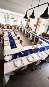 a long table in a room with tables and chairs at Auberge les plantades in Laviolle