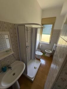 a bathroom with a shower and a sink and a toilet at Hotel La Quiete in Sinagra