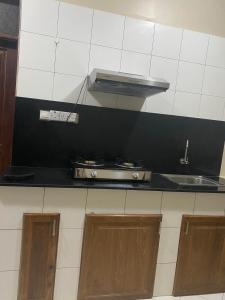 a kitchen with a stove and a counter top at Serenity Garden House in Nkunjila