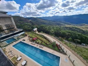 an aerial view of a resort with a swimming pool and mountains at Resort Gran Paradiso Campos do Jordão in Campos do Jordão