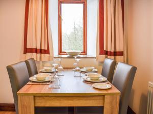 a dining room table with chairs and a table and a window at Spring Grove in Pooley Bridge