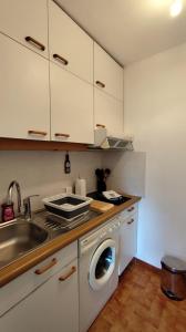 a kitchen with a sink and a washing machine at Sullensa # Parking - Proche Centre - Vue Montagne in Thônes +17 photos