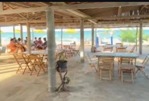 a restaurant on the beach with tables and chairs at Pousada Quinta das Flores in Icapuí +25 photos