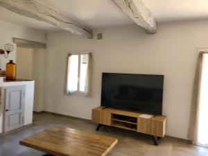 a living room with a flat screen tv on a wall at Maison au calme absolue in Saint-Cézaire-sur-Siagne