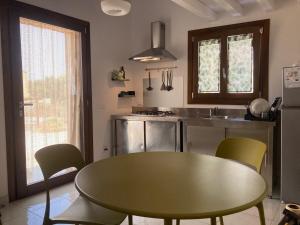 a kitchen with a table and chairs and a sink at la casetta degli amici Ustica in Ustica