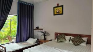 a bedroom with two beds and a window at Blue coconut villa in Kon Rung (1)