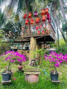a tree house with chairs and flowers in a garden at Blue coconut villa in Kon Rung (1) +11 photos