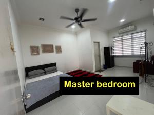 a bedroom with a bed and a ceiling fan at Almai Homestay Batu 4 in Port Dickson
