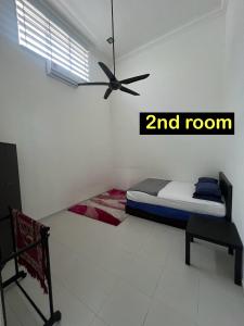 a bedroom with a bed and a room at Almai Homestay Batu 4 in Port Dickson