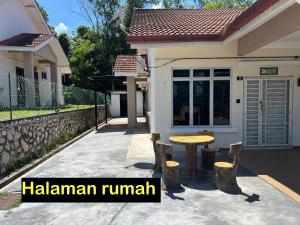 a house with a table and chairs in front of it at Almai Homestay Batu 4 in Port Dickson