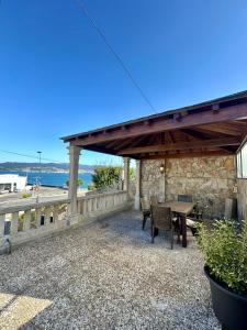 a patio with a table and chairs and the ocean at Chancelas A in Combarro