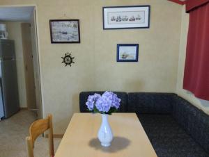 un jarrón de flores púrpuras sentado en una mesa en La Dolce Vida, en La Baule