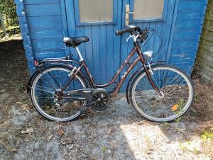 una bicicleta estacionada frente a una puerta azul en La Dolce Vida, en La Baule