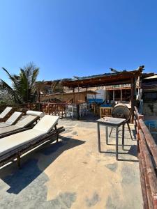 a group of beds and a table on a beach at Condominio Vista Pacífico in Máncora Chico