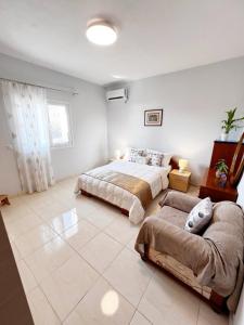 a bedroom with two beds and a couch at Maria 's aparment in Mursi
