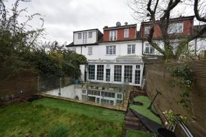 a large white house with a yard in front of it at Chiswick Guest Rooms in London