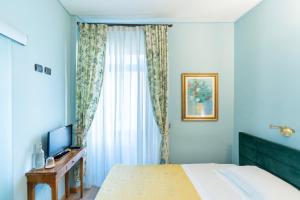 ein Hotelzimmer mit einem Bett und einem Fernseher in der Unterkunft Boutique Hotel Scalzi - Adults Only in Verona