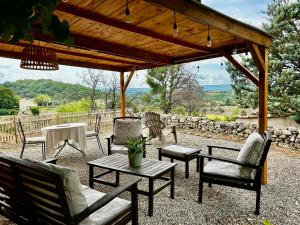 a group of chairs and tables under a wooden pergola at Les Demeures du Clos in Niozelles +64 photos